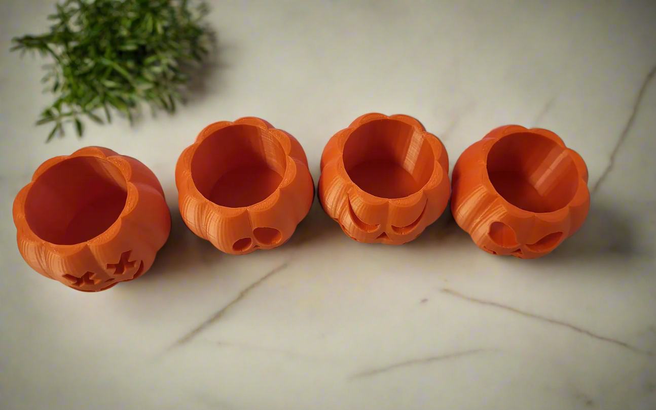 a set of 4 pumpkin shaped halloween tealight holders