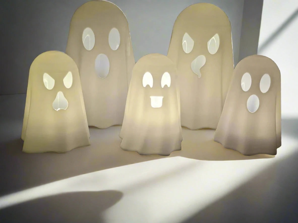 a set of 5 glowing ghosts toppers for tealight candles