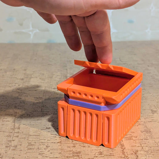 a hand pressing down the lid of a bandit box