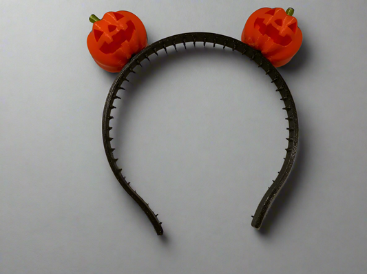 A picture of an hairband with two small pumpkin atop