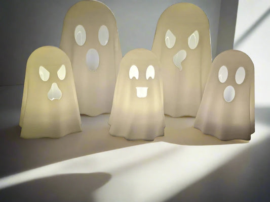 a set of 5 glowing ghosts toppers for tealight candles